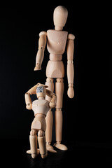 Two wooden mannequins. Selective focus. The concept of the trend of assigning QR codes to people in connection with countering the new Covid virus infection and global digitalization.