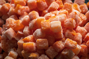 Frozen fresh carrot cube pieces closeup background