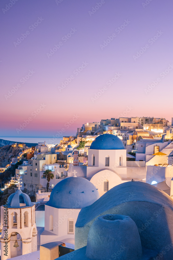 Wall mural colorful and dramatic sunset with night lights in mediterranean town of oia, santorini, greece, euro