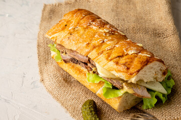 Cuban pork and cheese sandwich in a toasted baguette with butter, close-up.