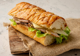 Traditional Cuban sandwich on a wooden board and a white table.