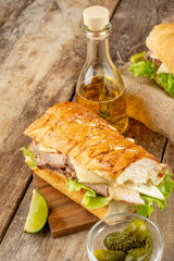Cuban sandwich with meat, traditional fast food. Wooden table. Vertical photo.