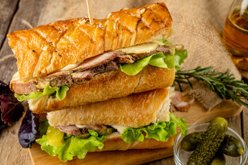 Large sandwiches stacked on top of each other. Cuban meat sandwiches.