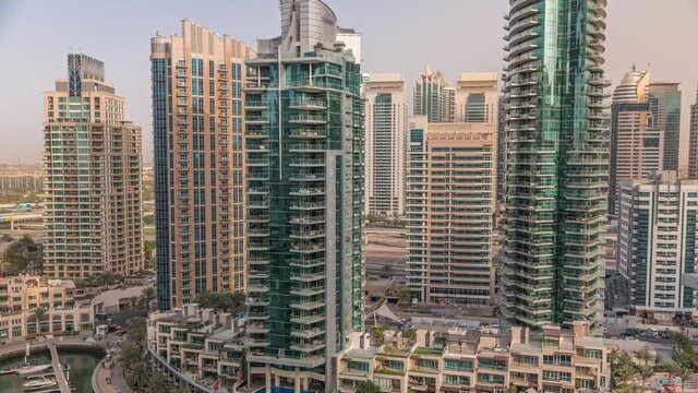 Dubai Marina luxury tourist district with skyscrapers and towers around canal aerial timelapse