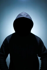 a silhouette of a man with a hoodie. a portrait of an unidentified person suitable for a campaign, advertisement, poster, etc. related to the dark web, nightlife, and street theme.