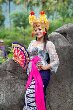 Balinese Dancer Woman Outdoors With Gold Headdress And Fan.