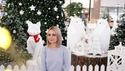 Portrait of a girl with blond hair on the background of a Christmas tree. Selective focus.