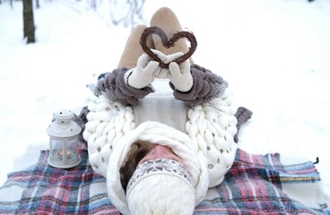 Portrait of a girl holding a handmade wooden Christmas decoration in the shape of a heart.