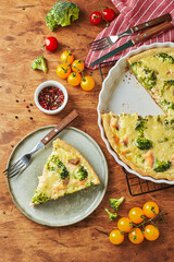 Homemade quiche with red fish, salmon, broccoli and cheese on wooden background