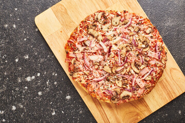 Fast food, Baked frozen pizza with ham, mushrooms and cheese on thick dough. Ready to eat.