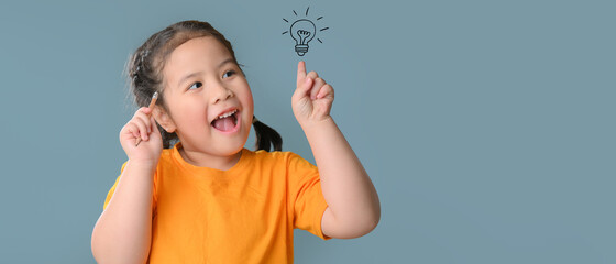Thinking a cute little asian girl on blue background with light bulb. Child thinking. Brainstorming and idea concept. Education concept.