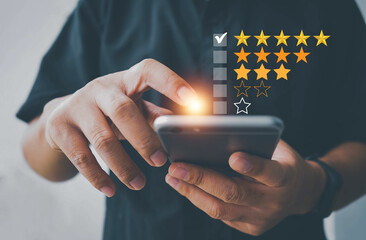 Customer review satisfaction feedback survey using smart phone and give five star symbol to...