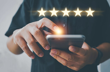 Customer review satisfaction feedback survey using smart phone and give five star symbol to increase rating of company concept, Customer service experience and business satisfaction survey.