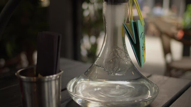 Standing Hookah glass with smoke in a lounge.