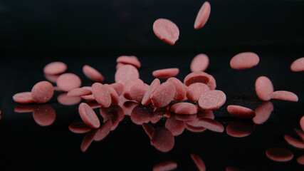 MACRO: Cinematic shot of milk chocolate droplets falling onto a countertop.