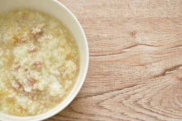 rice porridge with chop pork dressing soy sauce soup on bowl