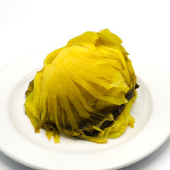 Pickled cabbage head on white plate. Traditional asian style preserving food with sour and salty taste. Spot focus
