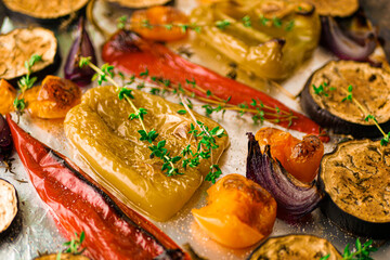 Fototapeta na wymiar Baked vegetables with spices, grilled peppers in the oven close-up, roasted vegetables background, vegan side dish recipe