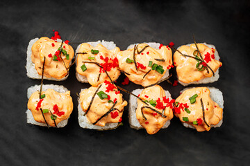 Cheese ebi sushi rolls with wasabi and soy sauce on black background