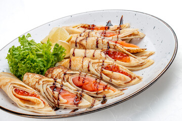 Pancakes stuffed with red caviar and salmon.  Russian dish. Isolated on a white background