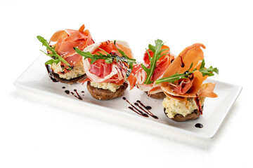 Grilled mushrooms stuffed with cheese and jamon. Isolated on a white background