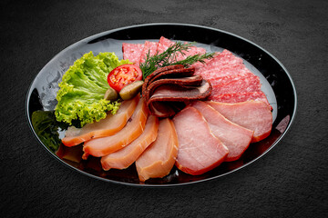 Assorted delicatessen meat snacks. Basturma, balyk, salami, sujuk and ham. Isolated on a black background