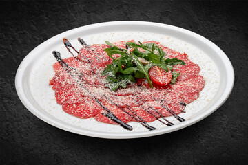 Veal carpaccio with parmesan cheese. Isolated on a black background