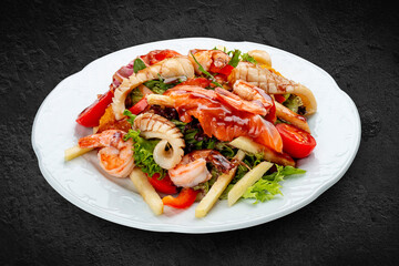 Salad Di Mare .Salad with shrimp, salmon and squid, orange and sweet pepper. Isolated on a black background