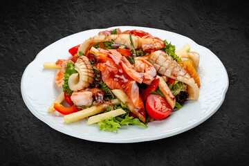 Salad Di Mare .Salad with shrimp, salmon and squid, orange and sweet pepper. Isolated on a black background