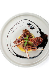 Rack of lamb with couscous with cherry sauce. Isolated on a black background