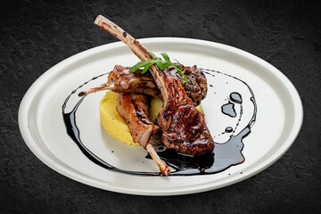 Rack of lamb with couscous with cherry sauce. Isolated on a black background