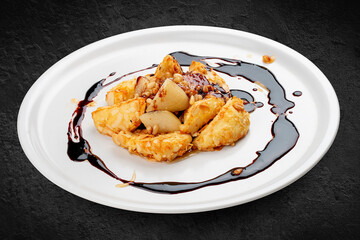 Suluguni in almond flakes with cherry sauce. Isolated on a black. background.
