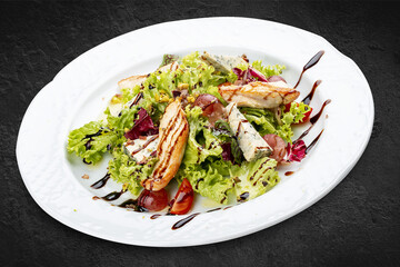 Salad with chicken fillet, dor blue cheese and pistachios. Isolated on a black background.
