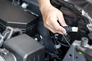 Close up hand a man LED bulbs are being inserted into the headlights of the car basic service concept do it yourself easily of car