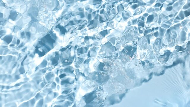 Poured water making splashes and ripples on blue background | skincare background, cleansing water commercial
