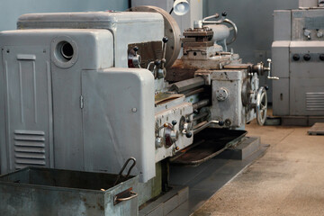 Old lathe stands in lathe shop in factory. Empty workspace. No people. Industrial background