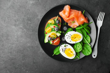 Delicious breakfast, tapas, appetizer. Bread, vegetables, herbs, spinach, eggs, salmon, berries, blueberries. Top view