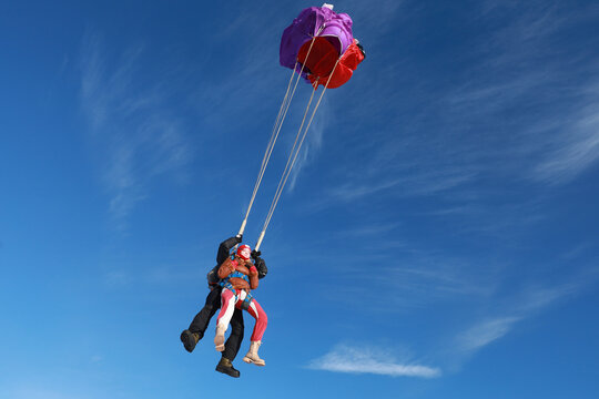 Skydiving. Tandem jump. A happy girl and her instructor are flying in the winter sky.