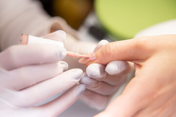 Obraz na płótnie Canvas applied varnish to a treated nail. Varnishing in a beauty studio close-up