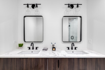 A beautiful modern bathroom with a wood vanity, white marble counter top, and a custom tiled stand...