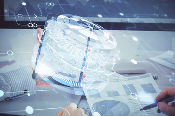 Double exposure of man's hand holding and using a digital device and data theme hologram drawing. Technology concept.