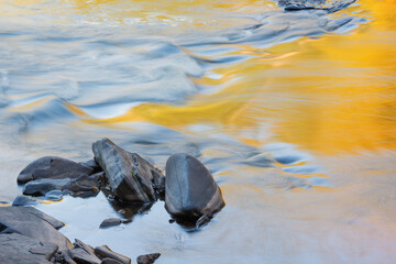 Landscape of the Presque Isle River rapids with reflections of sunlit foliage in calm water, Porcupine Mountains Wilderness State Park, Michigan's Upper Peninsula, USA 