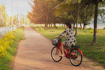 Fototapeta premium Woman riding bicycle on bike lane outdoors on seaside..