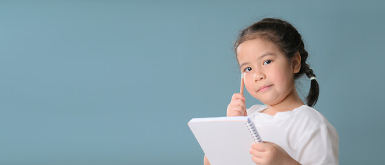 Thinking a cute little asian girl on blue background. Child thinking. Brainstorming and idea...