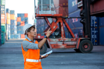 Foreman or worker hand holding tablet for writing and checking in goods in container at Container cargo site. 