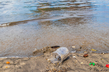 Plastic bottle stranded washed up garbage pollution on beach Brazil.
