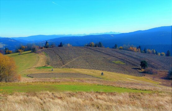 Plowed field with High Tatras background and blue sky in autumn.