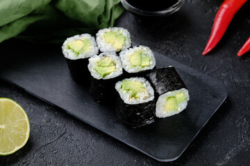 Japanese rolls with cucumber on a black background