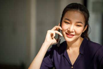 Young businesswoman sitting at the table and taking notes in table on the laptop computer, smartphone, and cup of coffee. graphics and charts. Student learning online.