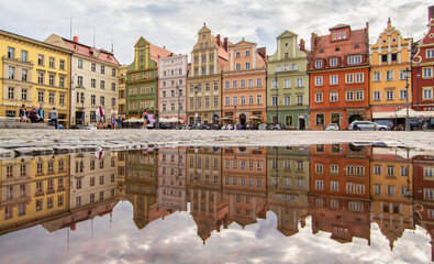 Fototapeta premium Wroclaw, Poland - due to the frequent rain, in Wroclaw you can easely find water pools, and use them to make nice shots. Here in particular the mirror effect in the Old Town